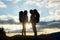 Couple of tourists in love with backpacks facing each other at sunset in the mountains