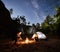 Couple tourists resting beside camp, campfire tent at night