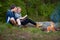 A couple of tourists in time of the hike, sitting and relaxing near the fire embracing