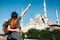 A couple of tourists a young man and a pretty woman embrace and look together at the world-famous Blue Mosque in