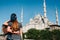 A couple of tourists a young man and a pretty woman embrace and look together at the world-famous Blue Mosque also