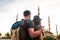 A couple of tourists a young man and a pretty woman embrace and look together at the world-famous Blue Mosque also