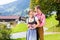 Couple in Tracht standing on meadow in alp mountains