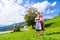 Couple in Tracht standing on meadow in alp mountains