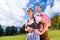 Couple in Tracht standing on meadow in alp mountains