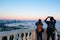 Couple traveler use smart mobile phone and camera take photo of view of Baku caspian sea and Baku sky scape view in sunset at Buku