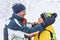 Couple of travelers look at each other, hugging on the background of a blurry winter landscape