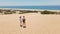 couple travelers tourists walking sandy dunes on beautiful Patara Beach on Mediterranean sea coastline. stunning desert