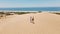 couple travelers tourists walking sandy dunes on beautiful Patara Beach on Mediterranean sea coastline. stunning desert