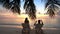 Couple on a tropical beach are admiring the sunset.