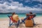 Couple on tropical beach in loungers