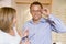 Couple trying on eyeglasses at optometrists