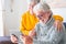 Couple of two cheerful and happy mature and old people seniors using tablet and having fun sitting on the sofa at home together.