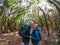 Couple of two happy and healthy seniors and mature people in a forest trekking and walking together - pensioner man and woman