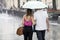 Couple under umbrella walking in heavy summer rain