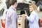 Couple Unloading New Television From Car Trunk