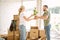 Couple unpack boxes in new home. Woman giving flower to her husband