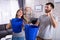 Couple Using Bucket For Collecting Water Leakage From Ceiling