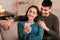 Couple using cell phone sitting on sofa