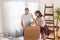 Couple using packing machine, taping the boxes while moving house