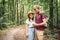 Couple using smart phone to navigate in woods. Theme tourism and navigation, search way, create route, gps phone app. Two people