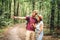 Couple using smart phone to navigate in woods. Theme tourism and navigation, search way, create route, gps phone app. Two people