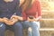 Couple using their smartphones are sitting in a park, which conveys the concepts of technology social media