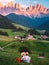 couple on vacation in the Italian Dolomites, Santa Maddalenavillage with magical Dolomites mountains in autumn, Val di