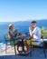 Couple on vacation in Santorini Greece, men and women having breakfast in a traditional dome house