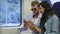 couple is viewing pictures in smartphone, riding by suburban train