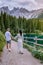 Couple visit hte bleu lake in the dolomites Italy, Carezza lake Lago di Carezza, Karersee with Mount Latemar, Bolzano