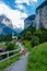 Couple visit Lauterbrunnen valley with waterfall and Swiss Alps in the background Switzerland