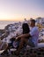 Couple visit Santorini Greece, men and women visit the whitewashed Greek village of Oia