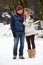 Couple Walking Along Snowy Street In Ski Resort