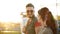 Couple walking in amusement park. Hipster man and stylish woman go to ride on ferris wheel. Boyfriend and girlfriend