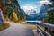 Couple walking around a Vorderer/Gosausee lake. Nise autumn scene of Alps with Dachstein glacier on background. Great morning view