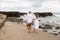 Couple walking barefoot along the beach. Back view. Romantic couple in love. Husband and wife travel together. Family relation