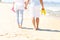 Couple walking at the beach and carrying flip flops