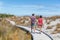Couple walking on beach holding hands romantic in New Zealand - young people in Ship Creek on West Coast of New Zealand
