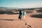 Couple walking at the beach of Maspalomas Gran Canaria Spain, men and woman at the sand dunes desert of Maspalomas