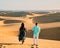 couple walking at the beach of Maspalomas Gran Canaria Spain, men and woman at the sand dunes desert of Maspalomas