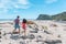 Couple walking on beach in New Zealand running having fun holding hands - young romantic couple in Ship Creek on West