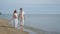 Couple walking beach. Pregnant couple on sea beach. Pregnant woman on beach