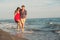 Couple walking on beach smiling holding around each