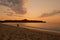 Couple walking on the beach during sunset.