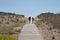 Couple walking on boardwalk toward sea beach