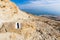 Couple walking desert trail down to Dead sea.