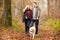 Couple Walking Dog Through Winter Woodland