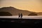 Couple walking on the edge of MassaguaÃ§u beach at dawn