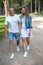 A couple walking hand-in-hand in a forest, smiling. Man and woman in white and jeans clothes. exudes warmth, family